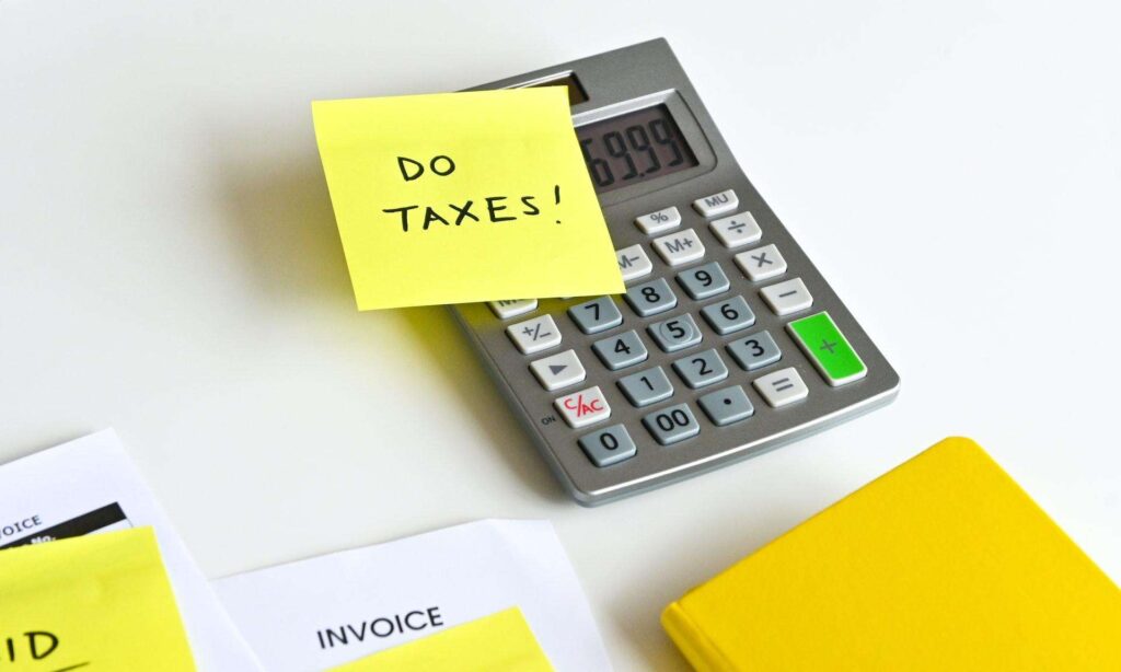 Calculator with a post-it note on top saying "Do Taxes!" as an overview of the Singapore tax system