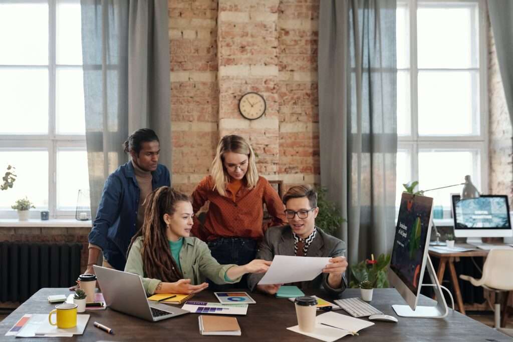 Workers in an office looking at a document with the salaries and rankings of different professions and job sectors in Singapore