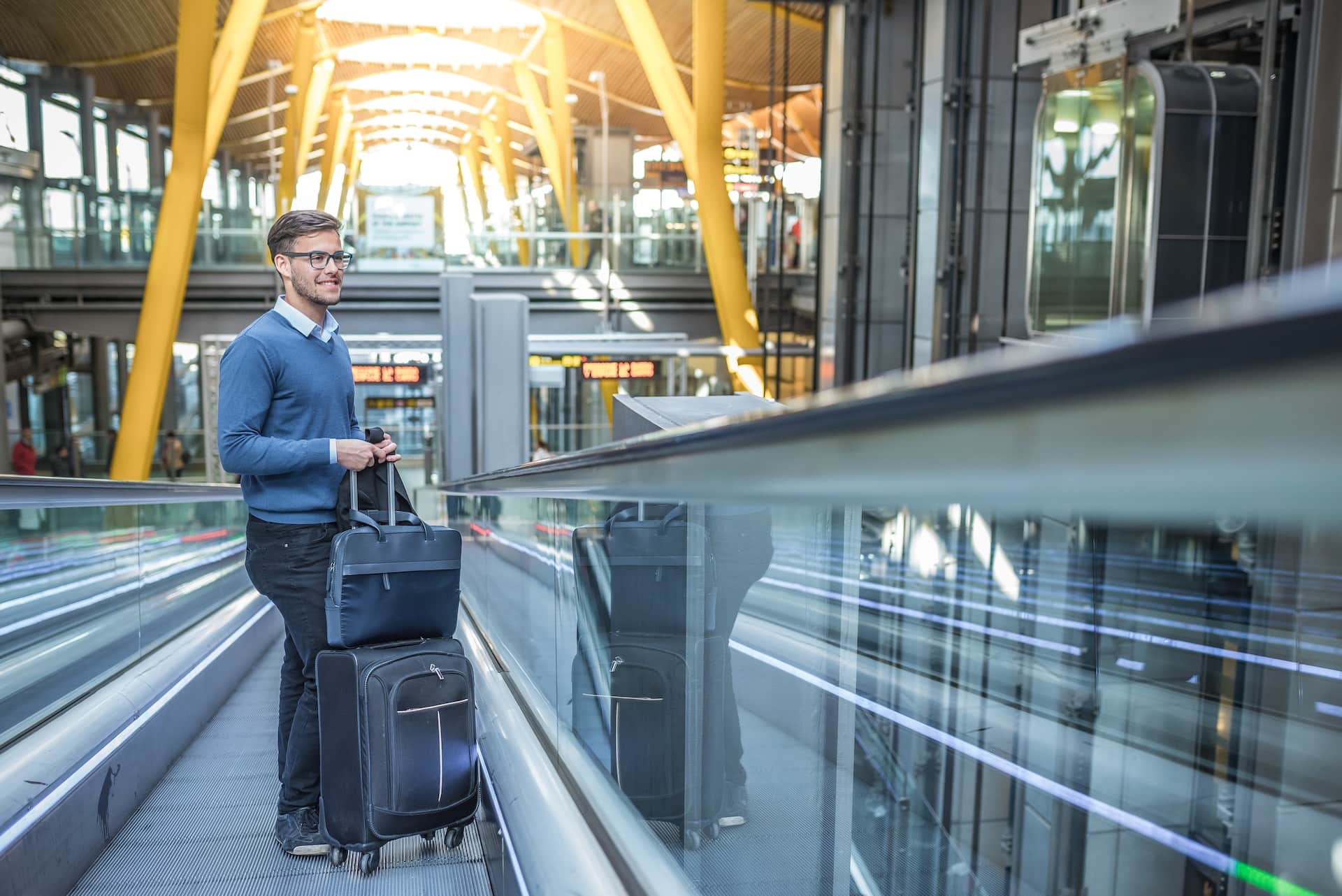 Foreign top talent worker awaiting to travel to Singapore under the Overseas Networks & Expertise Pass (ONE Pass Singapore) with luggage in hand at an airport.