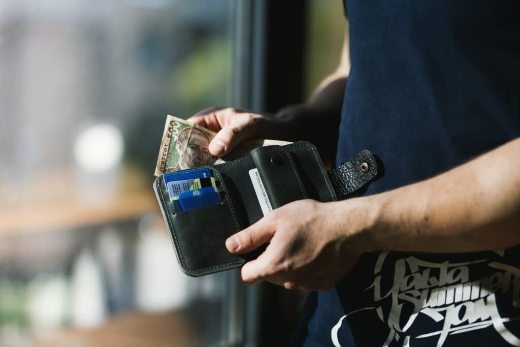 Tourist putting money into his wallet after claiming a GST Refund in Singapore